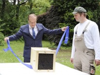 Imker Jürgen Dyckerhoff übergibt eine Bienenschwarm an Lutz Heese, Präsident der Bayerischen Architektenkammer.